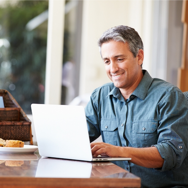 Asian woman looking at laptop smiling