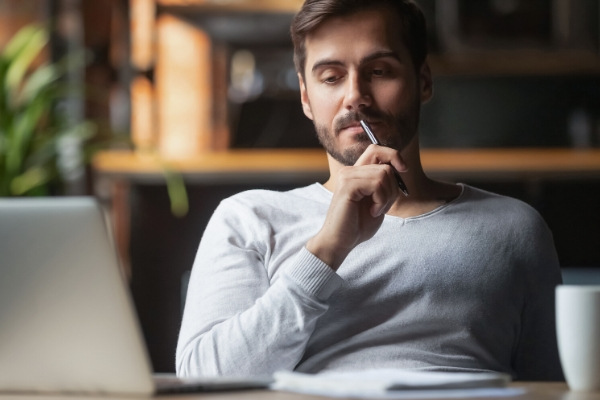 man thinking and looking at computer